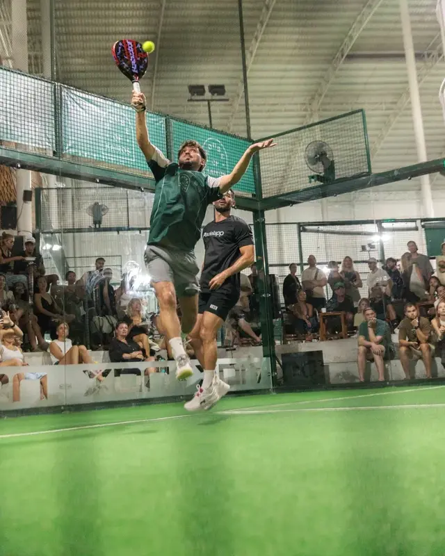 Flo jumping to hit a smash in a padel match
